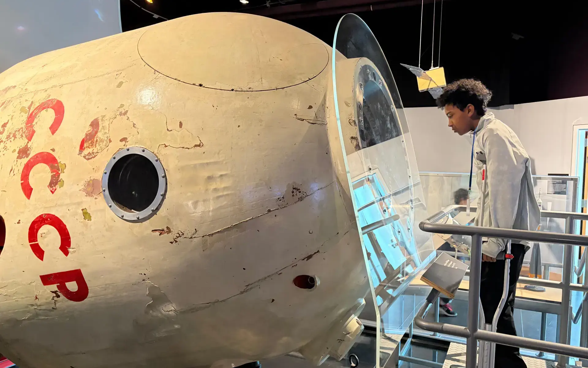 A Lower School boy looks in a space capsule replica at the Science Center. 