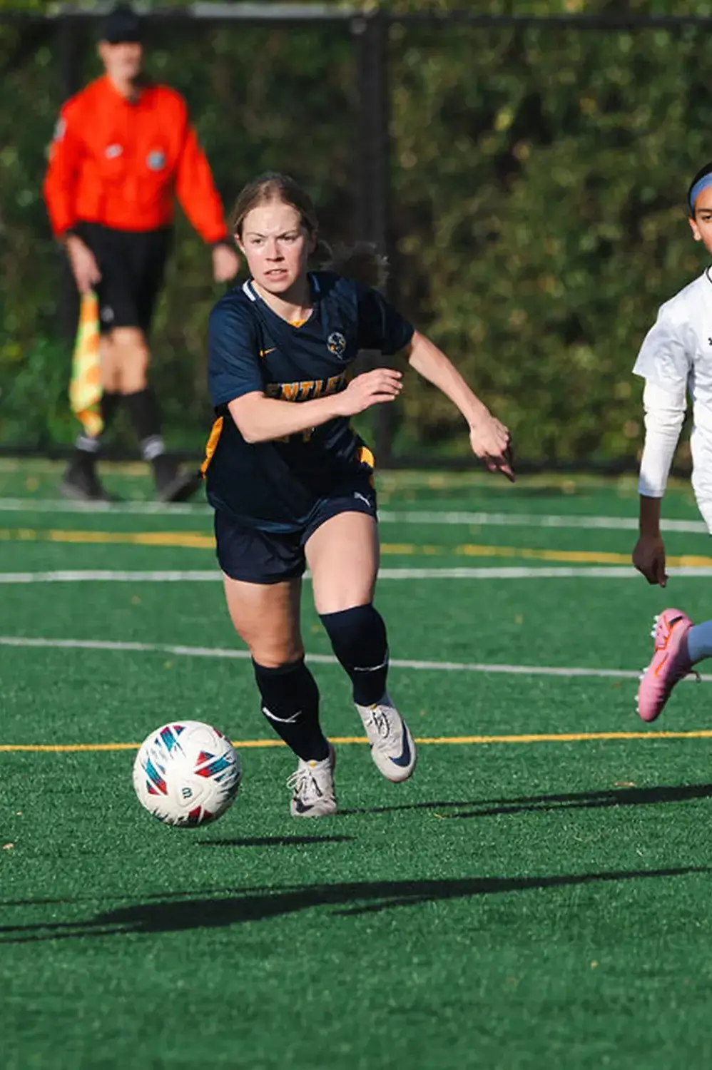 Upper School Girls' Soccer player charges the ball.