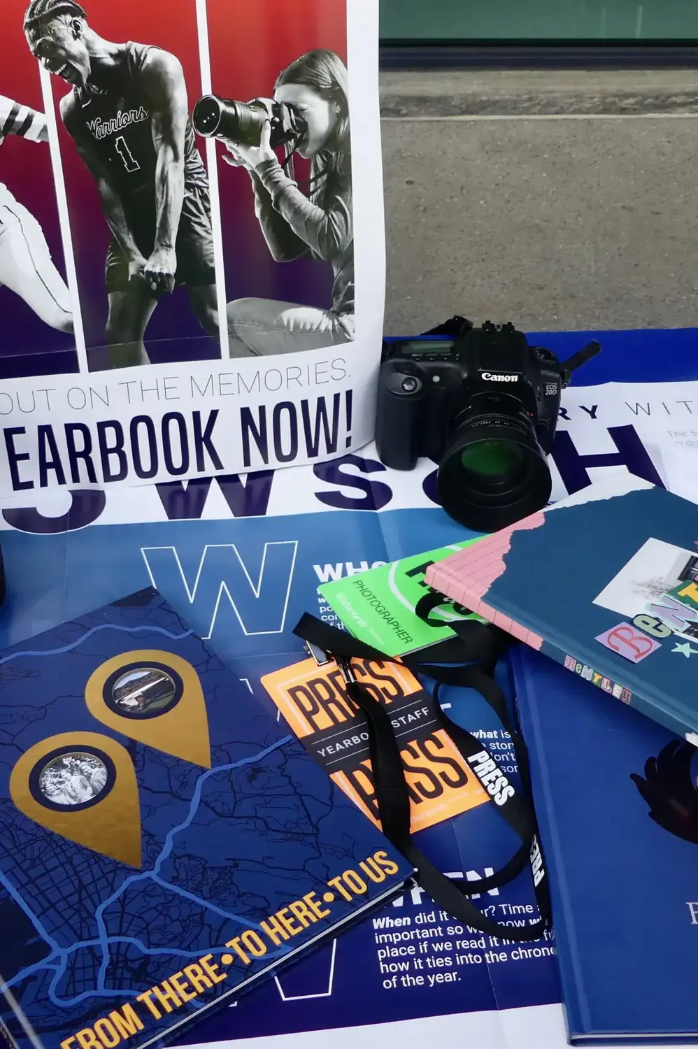 Bentley yearbooks and yearbook-related items are set up on a display table at a school club fair. 