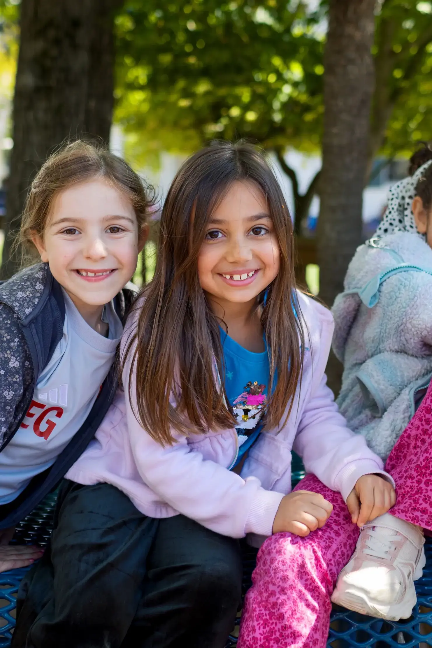 young students smiling together outdoors at bentley school
