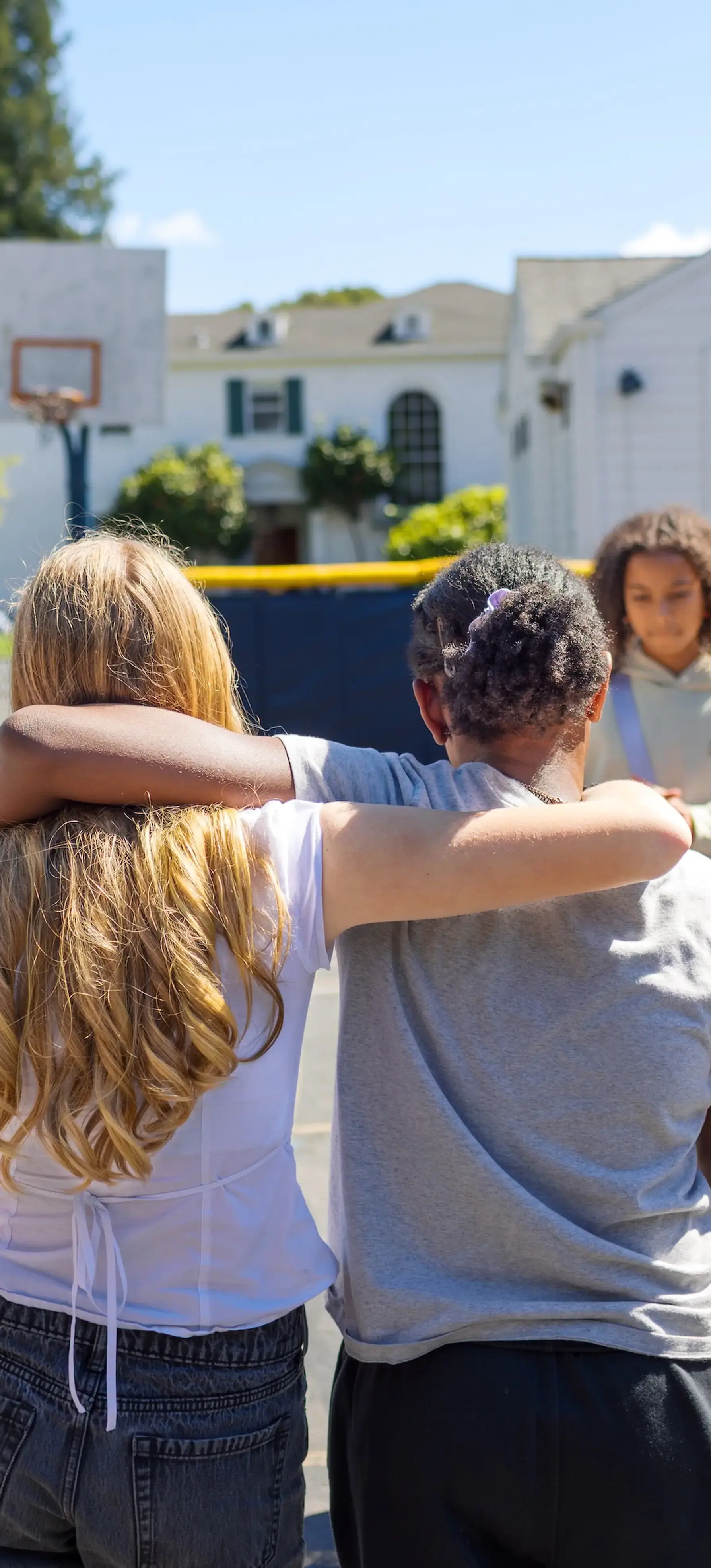 Middle School girls with their arms around each other's shoulders. 