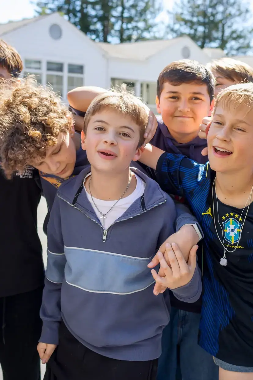 A large group of Middle School boys joking around. 